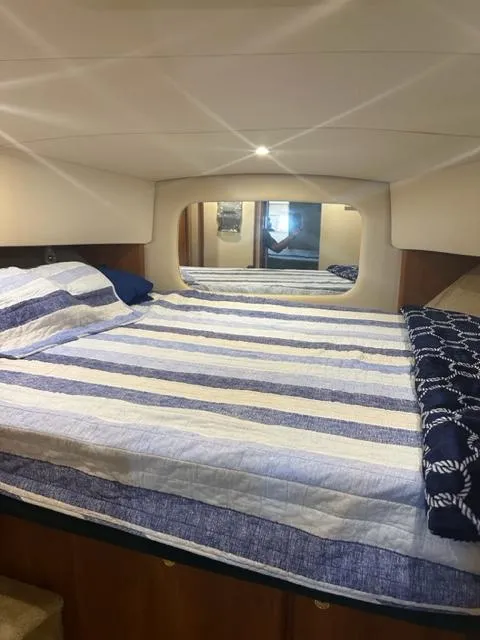 Slide: The Image of 1998 Silverton 372 Motor Yacht bedroom with striped bedding and mirror. - 35