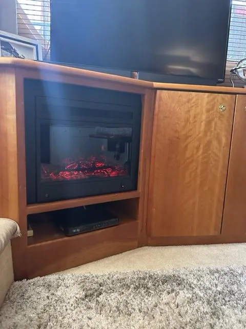 Slide: The Image of 1998 Silverton 372 Motor Yacht interior with electric fireplace and wooden cabinetry. - 41