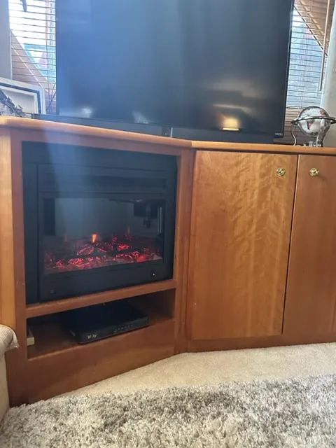 Slide: The Image of 1998 Silverton 372 Motor Yacht interior with fireplace and TV setup. - 42