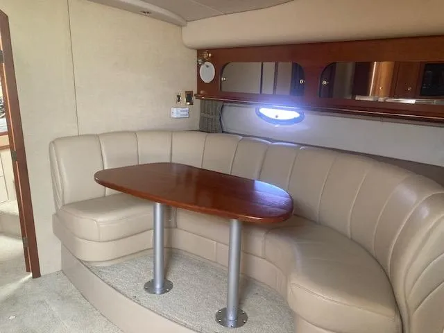 Slide: The Image of 2000 Cruisers Yachts 3575 Express interior with beige seating and wooden table. - 16