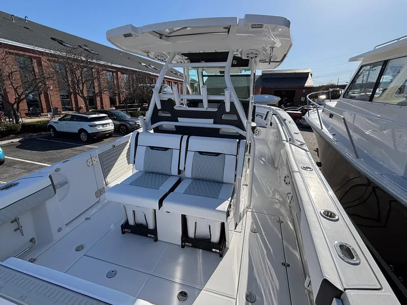 Slide: The Image of 2025 Blackfin 332 CC boat with sleek seating and modern design in a marina setting. - 12