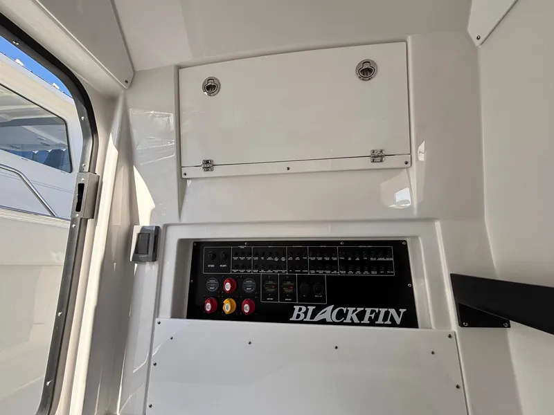 Slide: The Image of 2025 Blackfin 332 CC control panel with switches and storage compartment. - 19