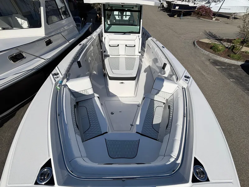 Slide: The Image of 2025 Blackfin 332 CC boat with spacious seating and sleek design in a marina setting. - 4