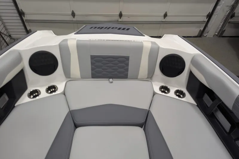 Slide: The Image of 2025 Malibu Wakesetter 24 MXZ interior with gray seating, cup holders, and speakers. - 10