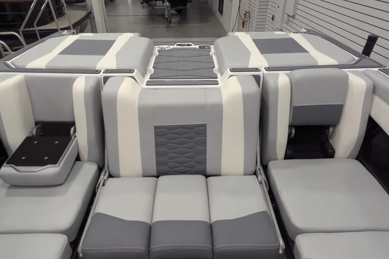 Slide: The Image of 2025 Malibu Wakesetter 24 MXZ interior seating, featuring gray and white upholstery. - 15
