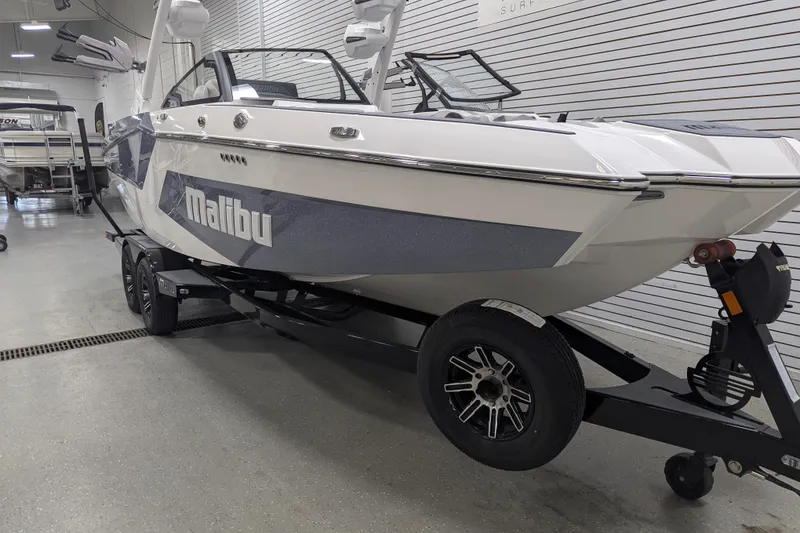 Slide: The Image of 2025 Malibu Wakesetter 24 MXZ boat on trailer in showroom. - 2