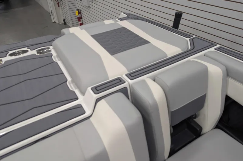 Slide: The Image of 2025 Malibu Wakesetter 24 MXZ boat interior with sleek gray and white upholstery. - 25