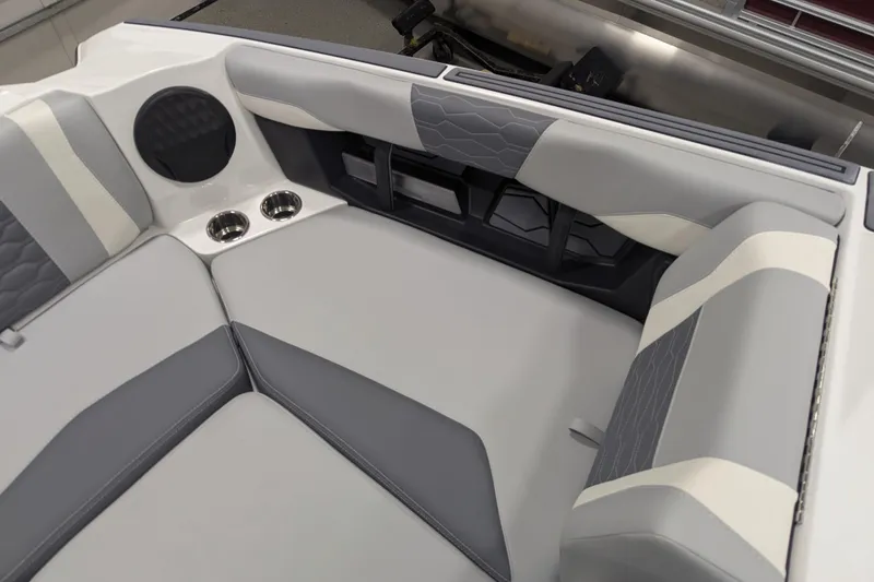 Slide: The Image of 2025 Malibu Wakesetter 24 MXZ interior with gray and white seating, cup holders, and speaker. - 9