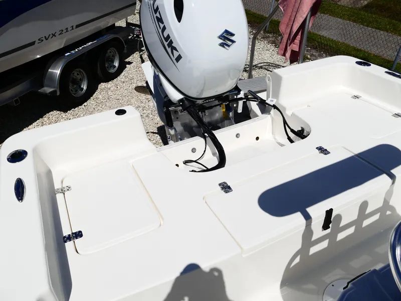 Slide: The Image of 2025 Bulls Bay 2000 boat interior with seating and steering console, parked on gravel. - 23