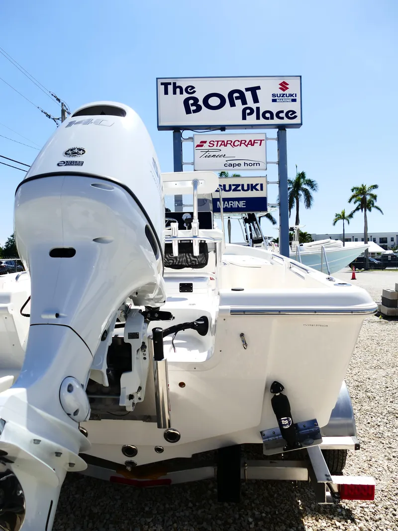 Slide: The Image of Bulls Bay 2000 boat at dealership with palm trees and signage in background. - 3
