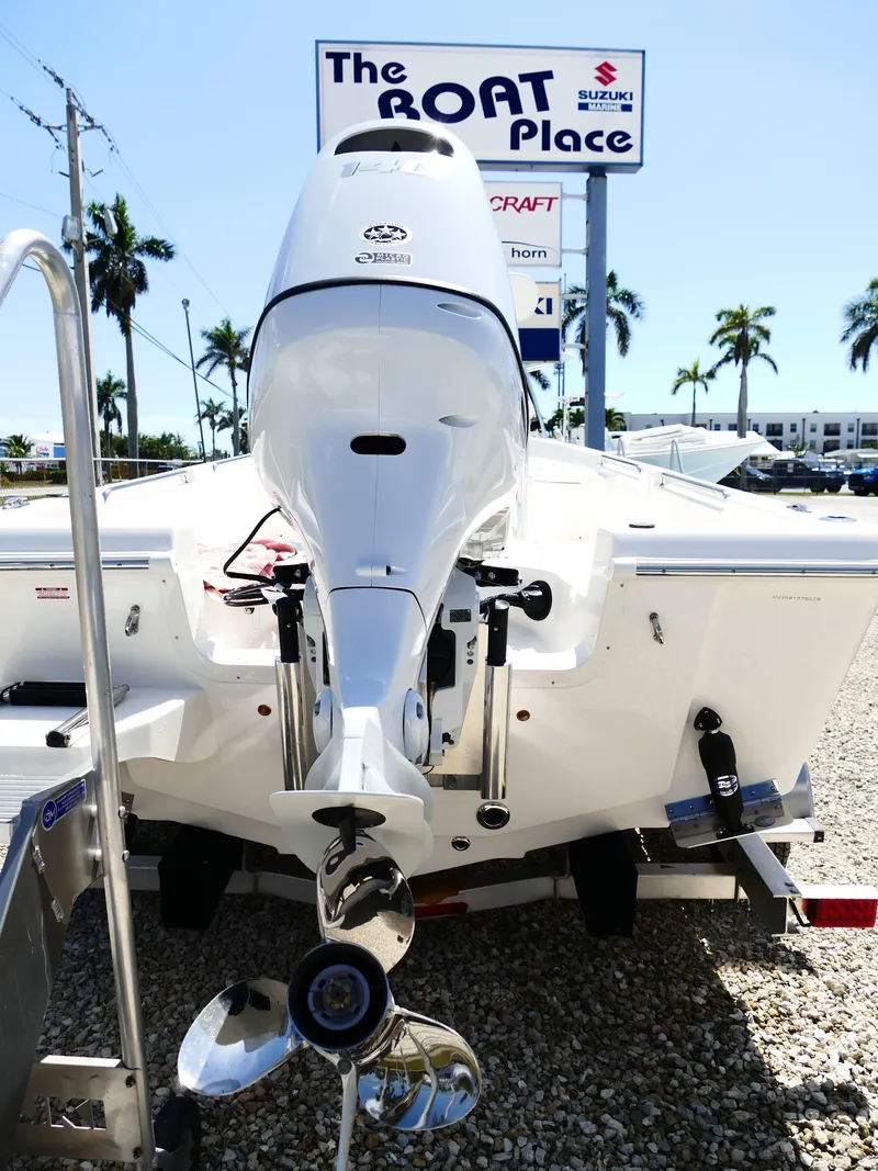 Slide: The Image of Bulls Bay 2000 boat at dealership with palm trees and signage in background. - 4