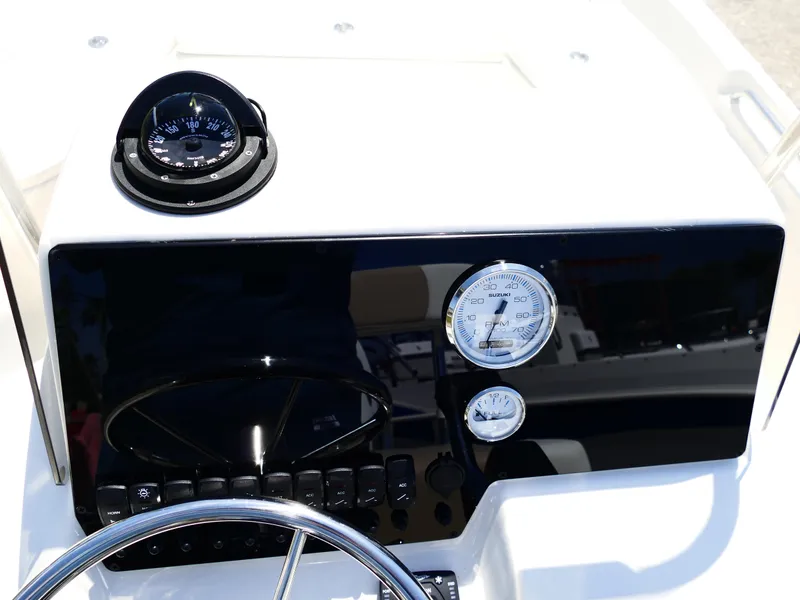 Slide: The Image of 2025 Bulls Bay 2000 boat with outboard motor at dealership, palm trees in background. - 8