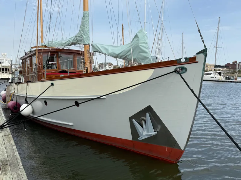 Slide: The Image of Classic 1938 Alden yacht docked, featuring custom design by Rockport Marine, with wooden masts and elegant lines. - 21