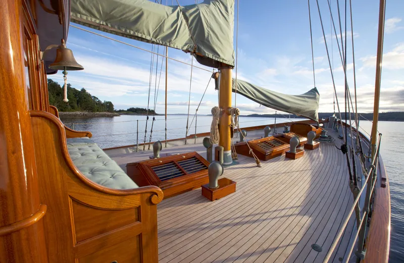 Slide: The Image of Elegant 1938 Alden yacht deck with wooden details, calm waters, and scenic view. - 27