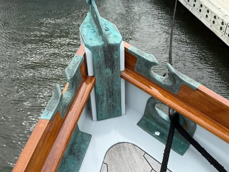 Slide: The Image of Bow of 1938 Alden custom boat with bronze fittings and wooden trim, docked on water. - 39