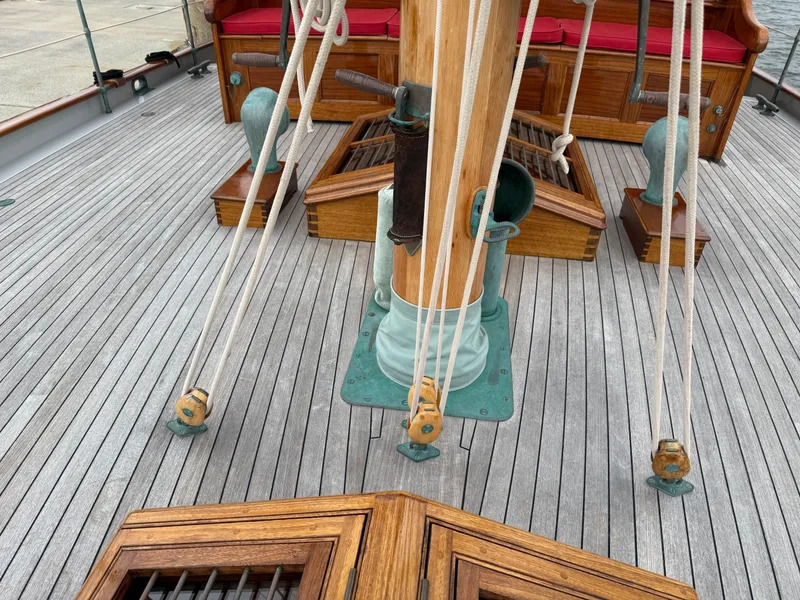 Slide: The Image of Deck of 1938 Alden sailboat, featuring wooden mast and rigging, restored by Rockport Marine. - 48