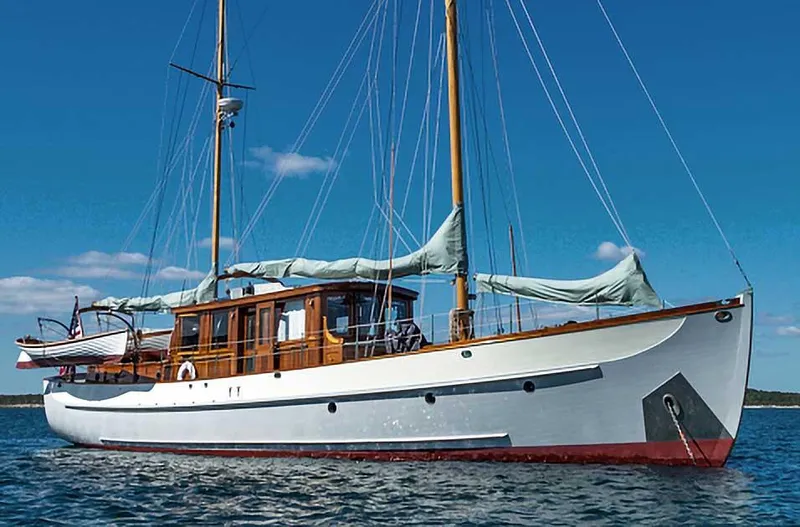 Slide: The Image of Classic 1938 Alden yacht with custom design, sailing on calm waters under a clear blue sky. - 5