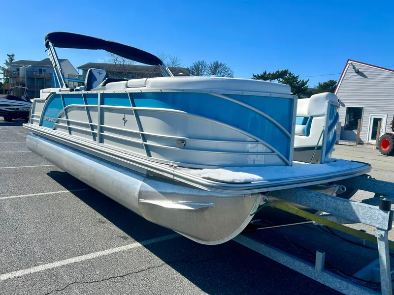 Slide: The Image of 2025 Berkshire 23RFX STS 3.0 pontoon boat on trailer in parking lot. - 1