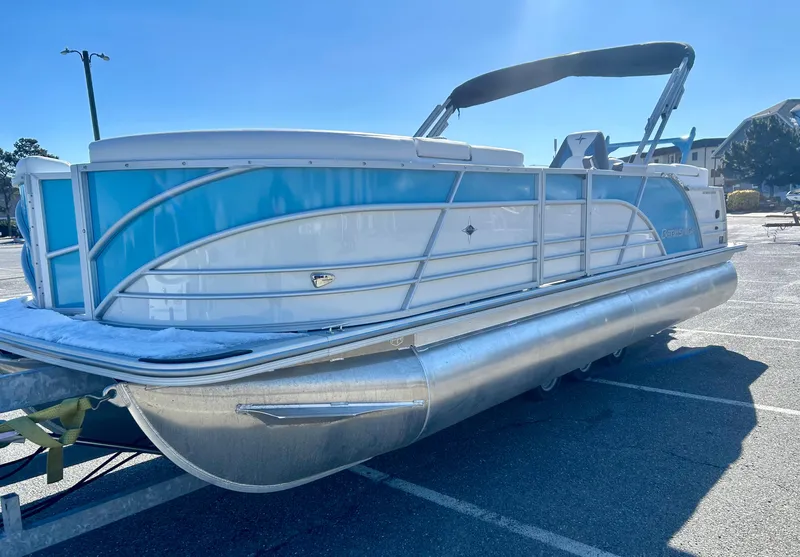 Slide: The Image of 2025 Berkshire 23RFX STS 3.0 pontoon boat with blue and white exterior in parking lot. - 5