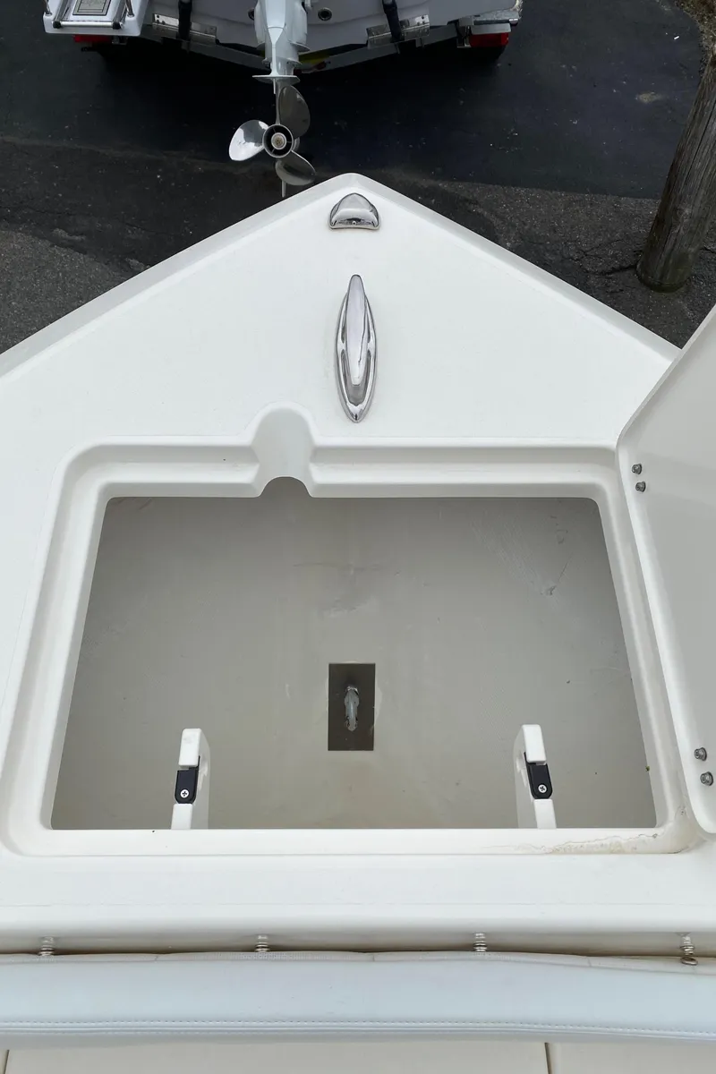 Slide: The Image of 2025 Cobia 220 boat storage compartment with open hatch, showcasing spacious interior. - 11