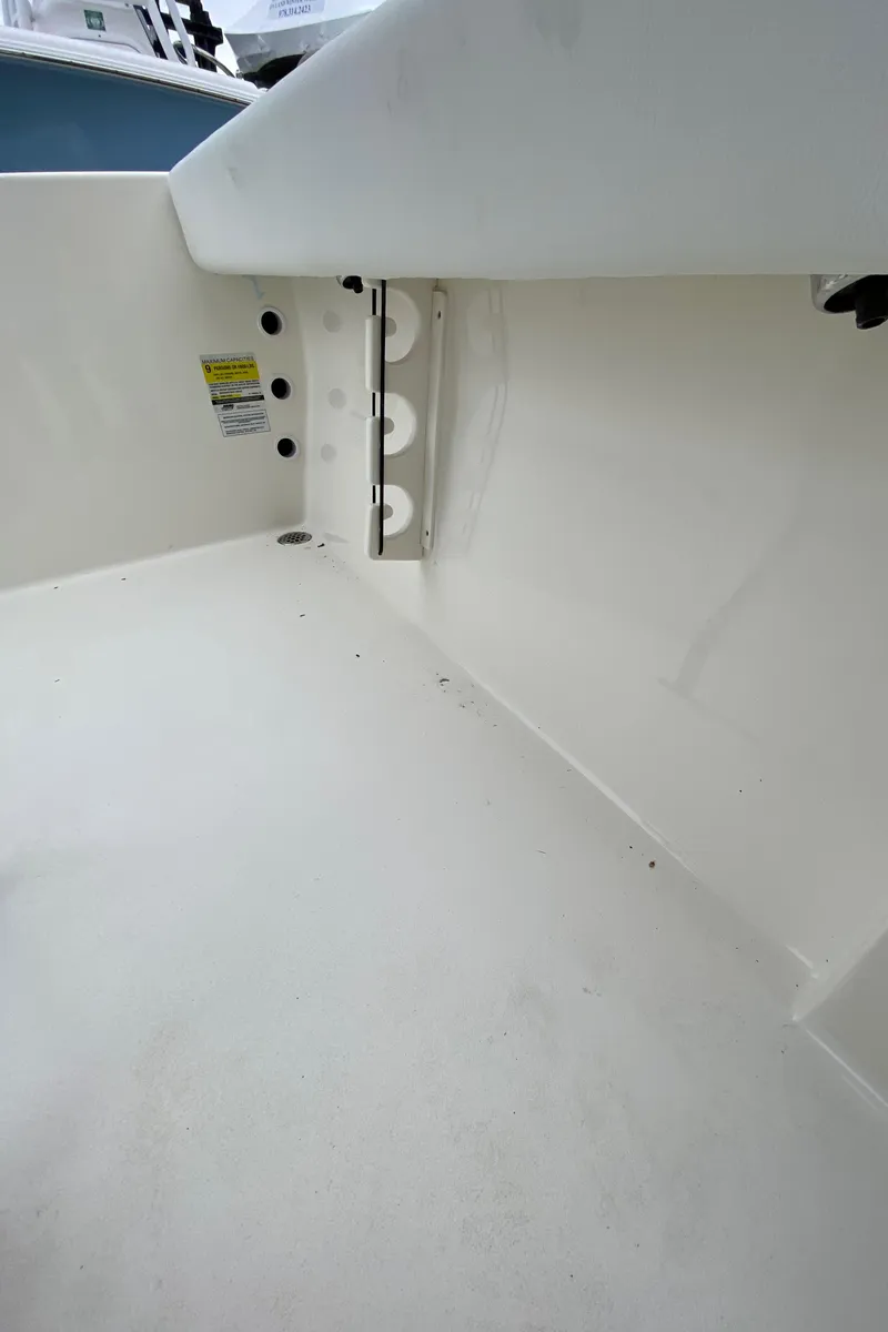 Slide: The Image of Interior view of a 2025 Cobia 220 boat, showcasing clean white surfaces and storage compartments. - 12