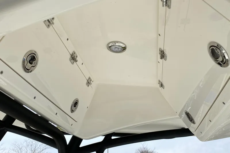 Slide: The Image of 2025 Cobia 220 boat storage compartments with secure latches and sleek design. - 15