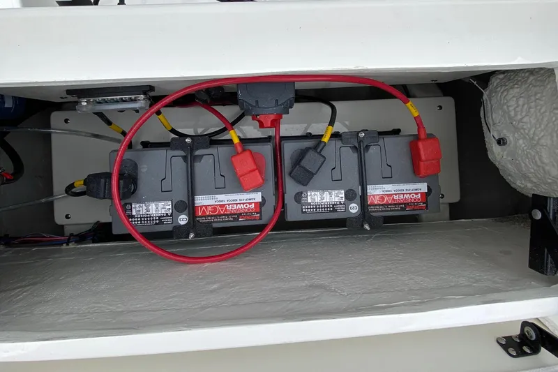 Slide: The Image of Battery compartment of a 2025 Cobia 220 boat, featuring dual power batteries. - 16