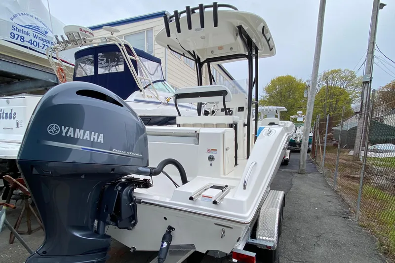 Slide: The Image of 2025 Cobia 220 boat with Yamaha engine, parked on a trailer in a marina. - 3