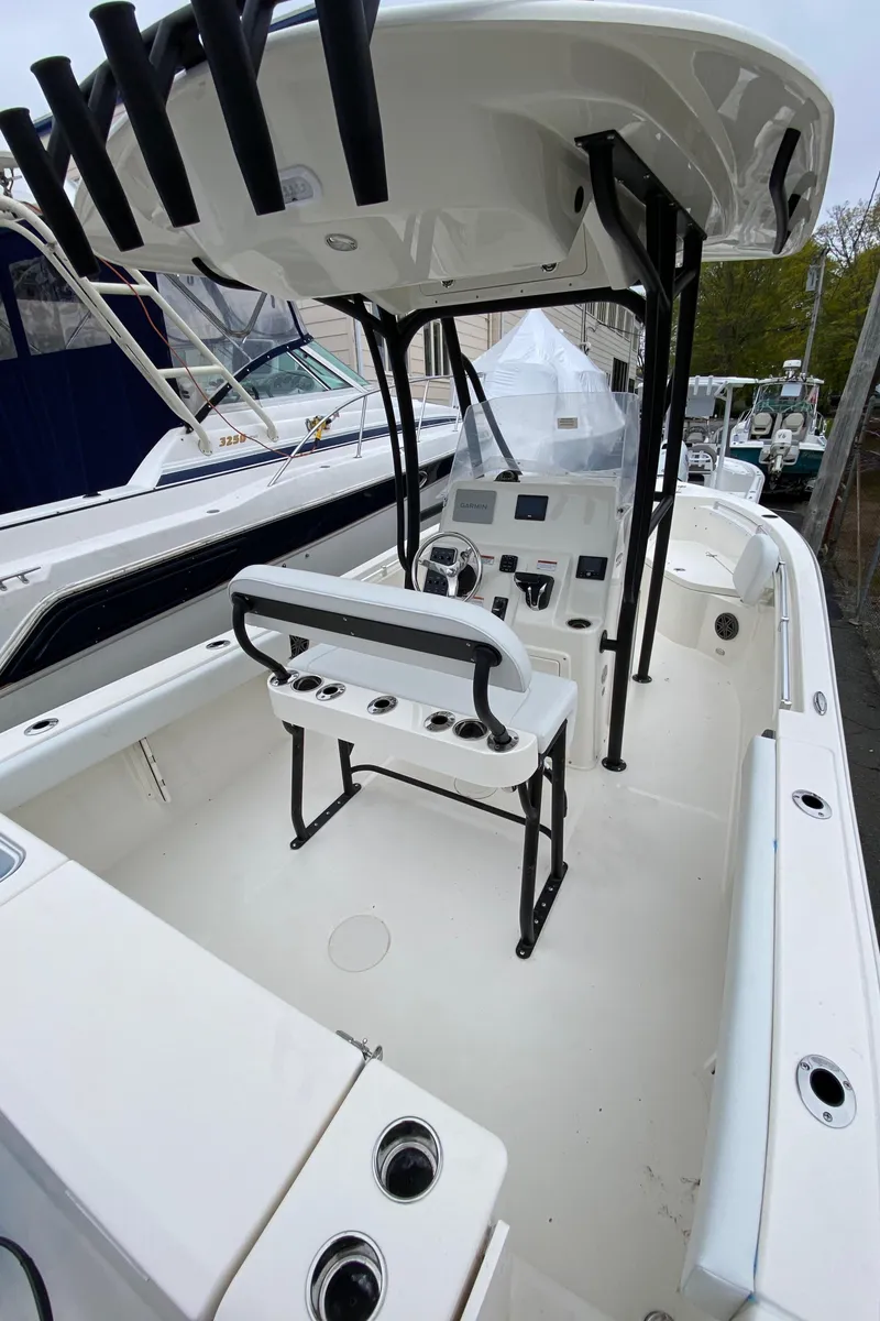 Slide: The Image of 2025 Cobia 220 boat interior with T-top and seating, showcasing modern design and functionality. - 4