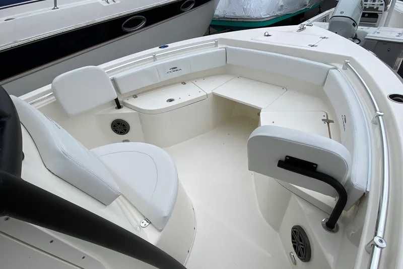 Slide: The Image of 2025 Cobia 220 boat interior with white seating and storage compartments. - 9