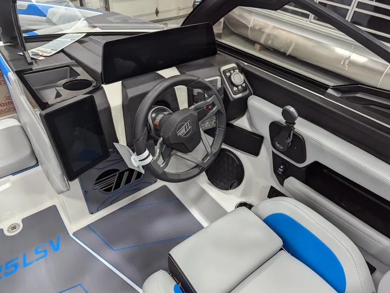 Slide: The Image of Interior of 2025 Malibu Wakesetter 25 LSV boat, featuring modern steering and controls. - 10