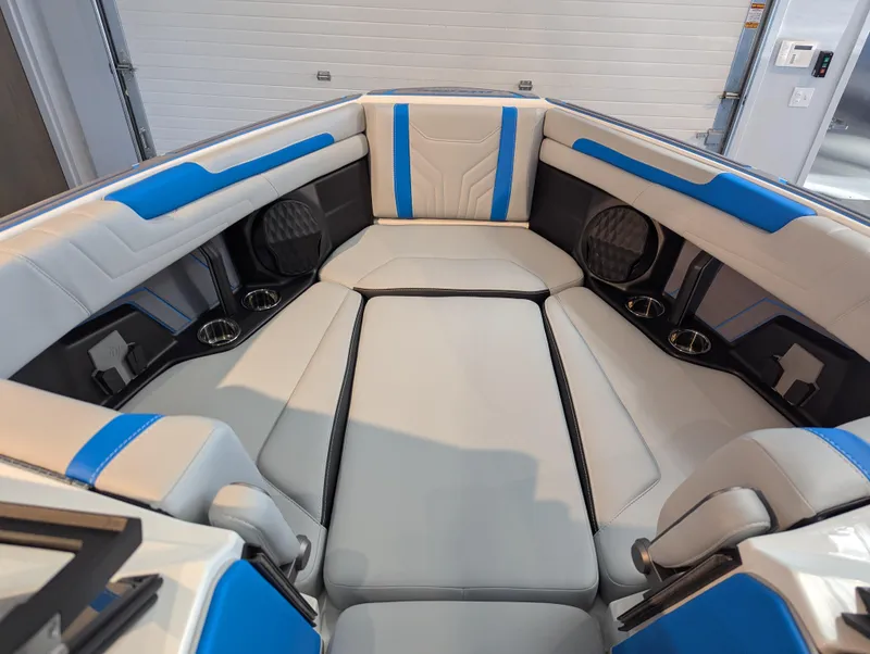 Slide: The Image of 2025 Malibu Wakesetter 25 LSV interior with blue and white seating, cup holders, and modern design. - 14