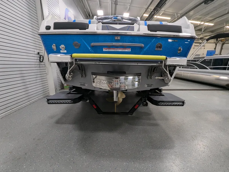 Slide: The Image of 2025 Malibu Wakesetter 25 LSV boat rear view in a showroom. - 2