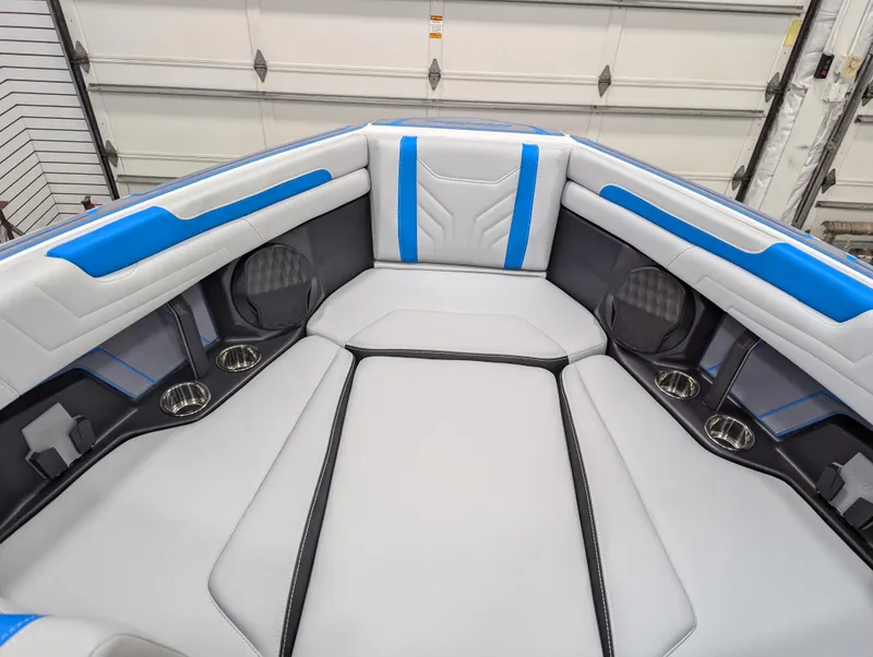 Slide: The Image of 2025 Malibu Wakesetter 25 LSV interior with blue and white seating, cup holders, and sleek design. - 5