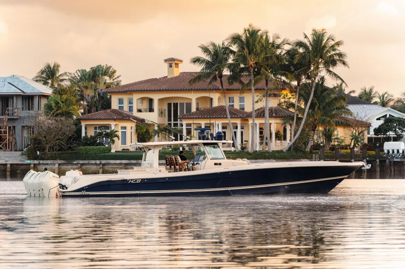 Slide: The Image of Luxury HCB 53 Sueños boat cruising near waterfront mansion, 2022 model. - 0