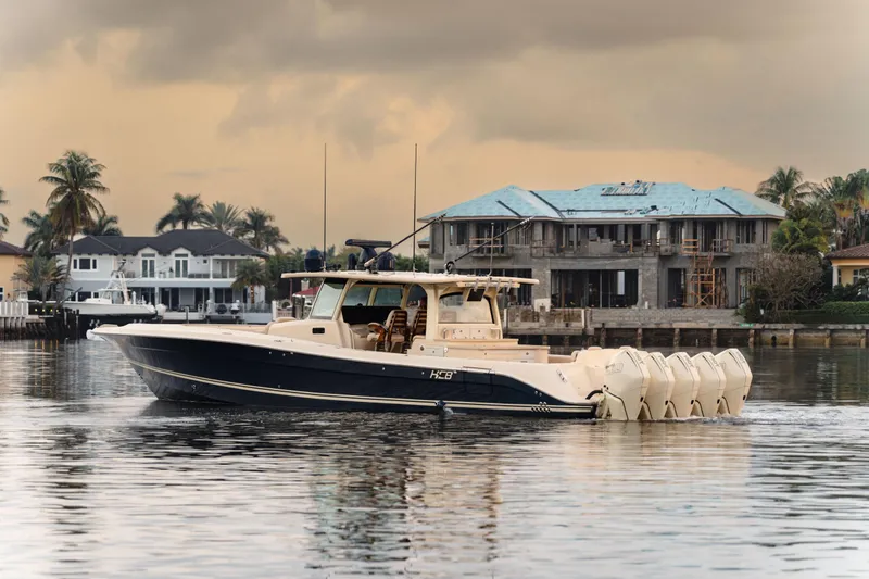 Slide: The Image of 2022 HCB 53 Sueños boat cruising near waterfront homes at sunset. - 1