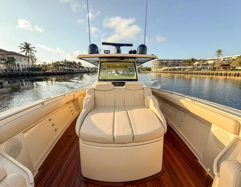 Slide: The Image of 2022 HCB 53 Sueños boat with luxurious seating and wooden deck on a calm waterway. - 12