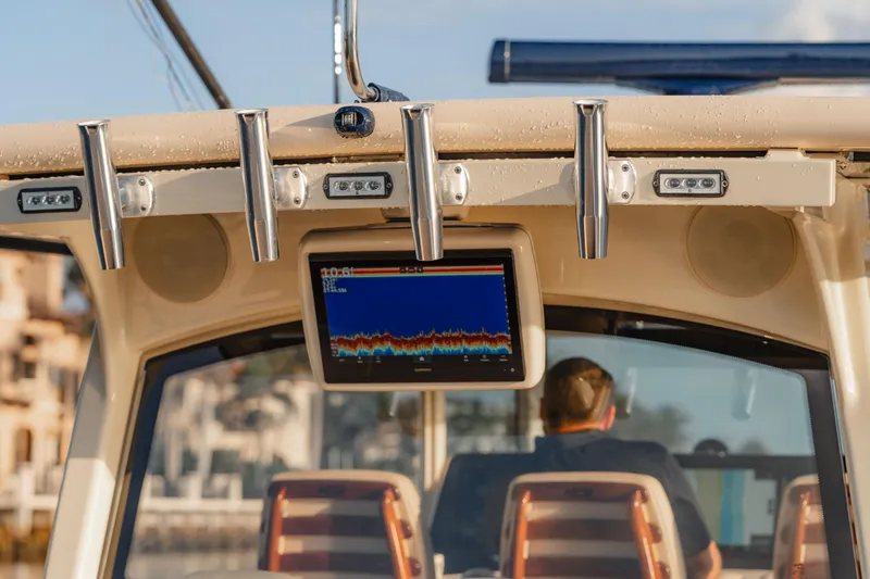 Slide: The Image of 2022 HCB 53 Sueños boat dashboard with navigation screen and rod holders. - 19