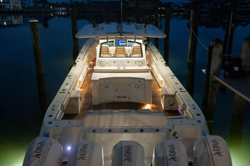 Slide: The Image of 2022 HCB 53 Sueños boat illuminated at night, docked with multiple engines. - 2