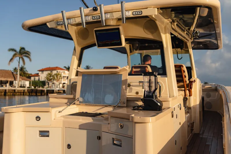 Slide: The Image of 2022 HCB 53 Sueños boat with luxurious deck and modern amenities, docked near waterfront homes. - 24