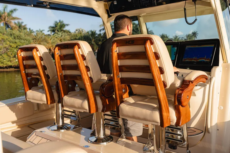 Slide: The Image of 2022 HCB 53 Sueños boat interior with luxurious wooden seating and modern navigation equipment. - 30
