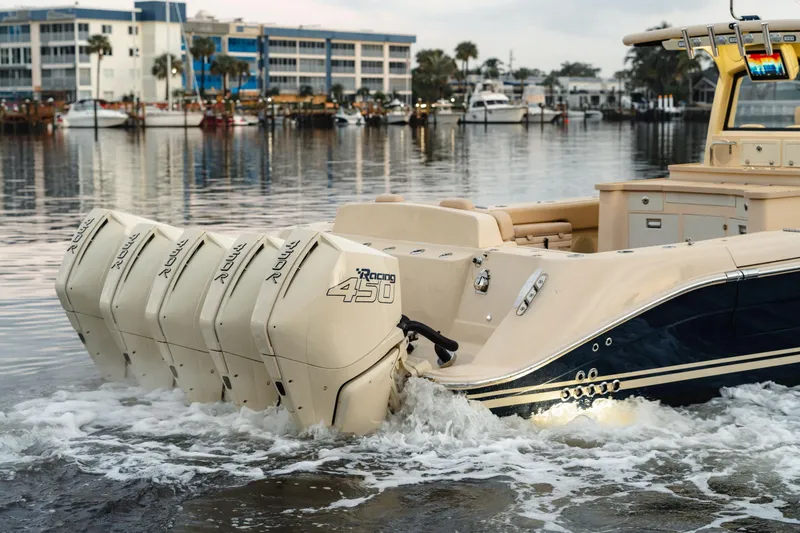 Slide: The Image of 2022 HCB 53 Sueños boat with multiple outboard engines on a calm waterfront. - 7