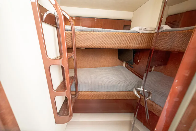 Slide: The Image of Bunk beds in 2008 Sea Ray 58 Sedan Bridge yacht cabin, featuring wooden accents and cozy bedding. - 39