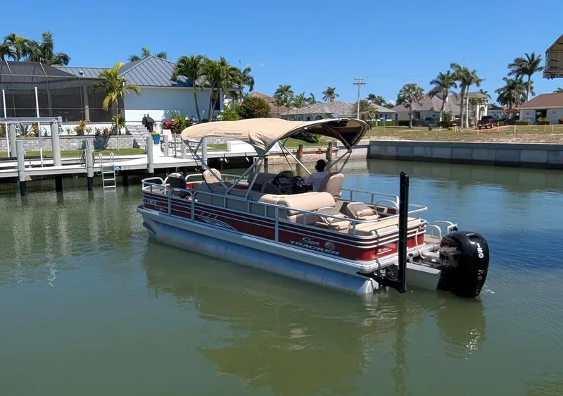 Slide: The Image of 2021 Sun Tracker Fishin' Barge 22 DLX pontoon boat docked in a sunny marina. - 2