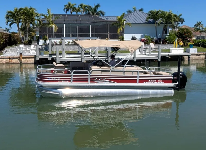 Slide: The Image of 2021 Sun Tracker Fishin' Barge 22 DLX pontoon boat on calm water near a dock. - 3
