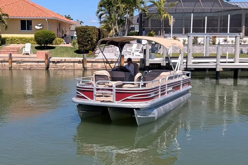 Slide: The Image of 2021 Sun Tracker Fishin' Barge 22 DLX pontoon boat on a calm waterway. - 4