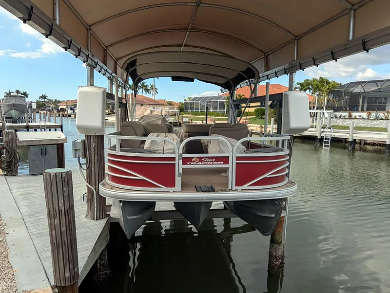 Slide: The Image of 2021 Sun Tracker Fishin' Barge 22 DLX pontoon boat docked under canopy. - 5