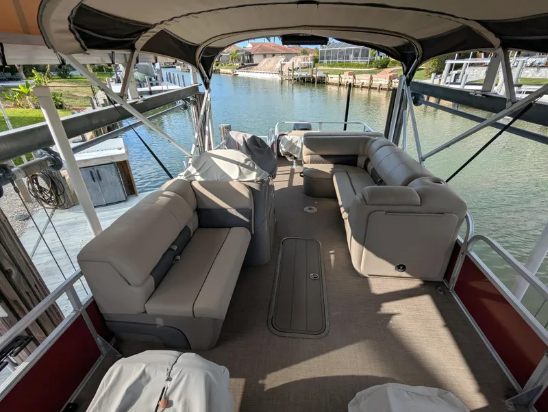 Slide: The Image of 2021 Sun Tracker Fishin' Barge 22 DLX interior with spacious seating and waterfront view. - 8