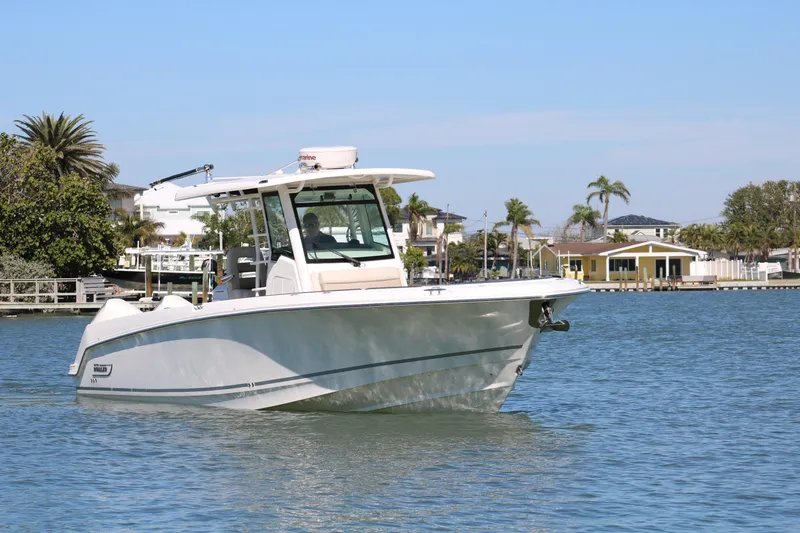 Slide: The Image of 2022 Boston Whaler 330 Outrage boat cruising on a sunny day in a coastal area. - 12