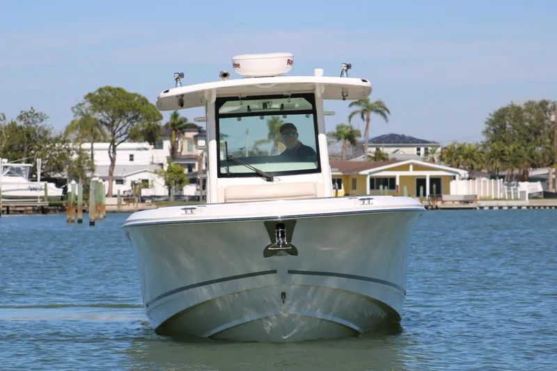 Slide: The Image of 2022 Boston Whaler 330 Outrage boat on calm water, front view. - 13